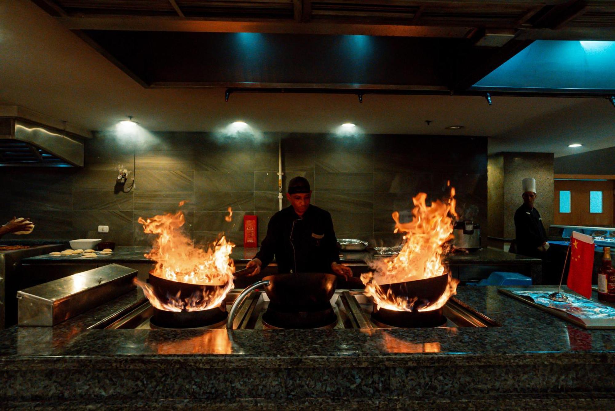 The V Luxury Resort Sahl Hasheesh 洪加達 外观 照片 A chef cooking with a wok