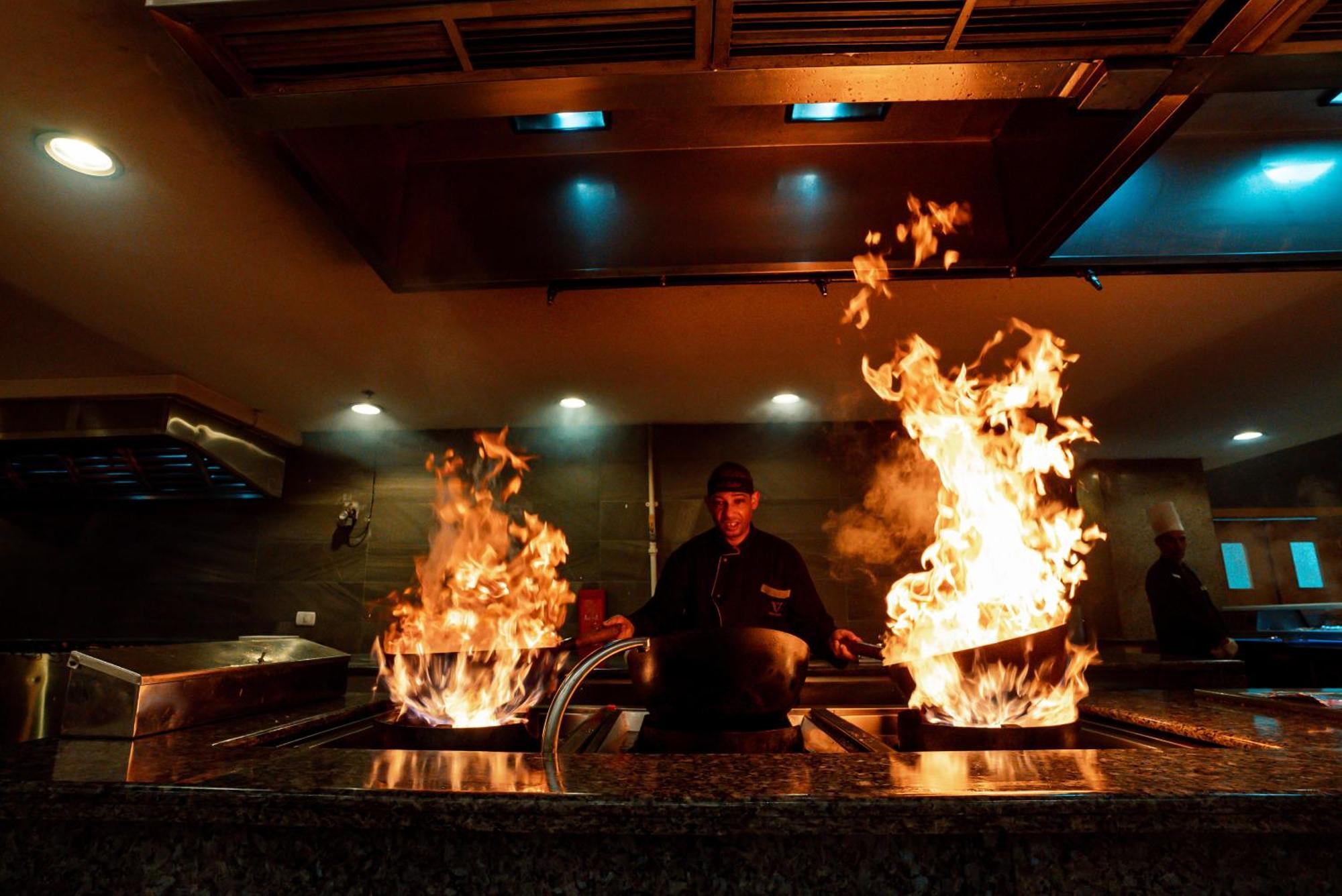 The V Luxury Resort Sahl Hasheesh 洪加達 外观 照片 A chef cooking with a wok